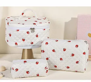 Lot de trois trousses à maquillage matelassées blanches avec motifs tomates et zips dorés