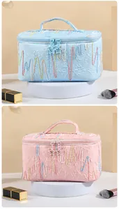 Detail of cream leather texture and star charm on blue and pink makeup bags
