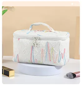 Macro shot of white vanity bag with star zippers and colorful wave embroidery