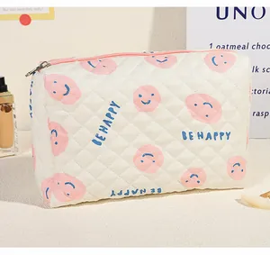 Detailansicht der gesteppten Kosmetiktasche in Creme mit pinkem Smiley und Metallreißverschluss
