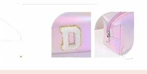 Detail of laser holographic pink makeup bag with plush letter D and gold embroidery