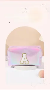 Detail of laser iridescent makeup bag with plush embroidered letter A and gold stitching