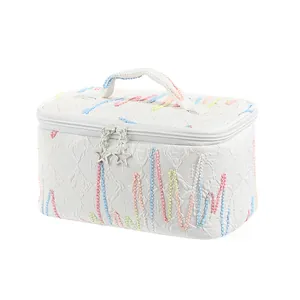 Large white cosmetic travel bag with colorful embroidery and star-shaped zipper pendants