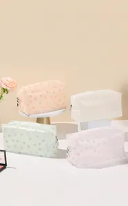 Macro shot of four-piece floral toiletry bags with frosted texture and silver zippers