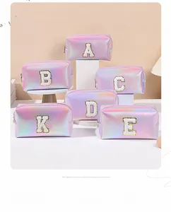 Macro detail of holographic makeup bag with pastel gradient and chenille letter patches