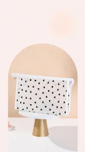 Detailed view of white mesh heart makeup bag featuring wide top zipper opening