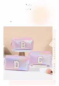 Close-up of holographic laser makeup bags with embroidered chenille patches and gold trim