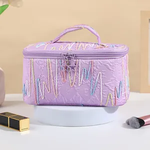 Quilted lavender cosmetic bag with star zippers and decorative colorful embroidery
