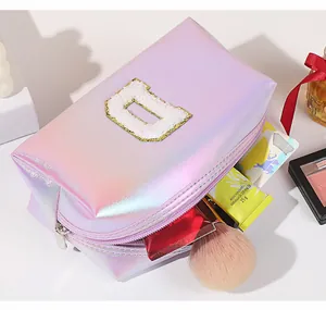 Detail of laser PU iridescent makeup bag with chenille letter D and silver zipper