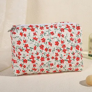 Gewatteerde make-uptas met rode bloemenprint en witte ritssluiting