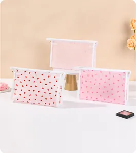 Three-piece pink mesh cosmetic bags with heart patterns and zipper closure for travel