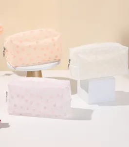 Detail of translucent floral makeup bags with zipper and matte finish in pastel colors