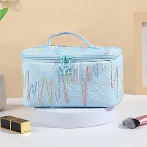 Light blue cosmetic bag with colorful wave embroidery and star zipper pulls