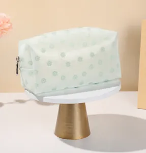 Close-up of green floral mesh makeup bag with durable silver metal zipper closure