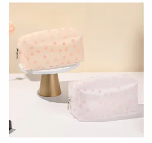 Detail view of two translucent floral toiletry bags with zippers in orange and pinkish white