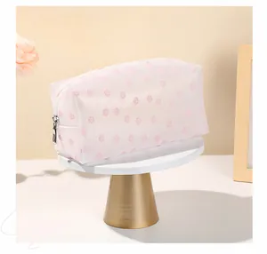 Detailed view of pink floral mesh makeup bag with zipper closure on a display stand