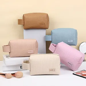 Stack of quilted PU leather cosmetic bags in five pastel colors with portable handles