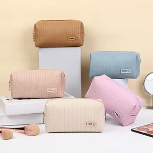 Quilted PU leather cosmetic bags with KTMO logo in various colors on white stands