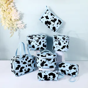 7-piece light blue cow print makeup bag set with various storage cases and silver zippers