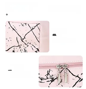 Detail of pink marble PU leather makeup bag showing dual silver metal zippers and texture