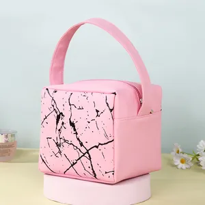 Pink square cosmetic bag with black marble pattern on a round pedestal display