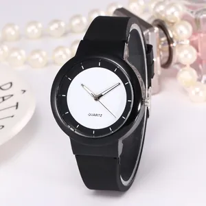 Detail view of quartz watch with black silicone strap and minimalist white dial