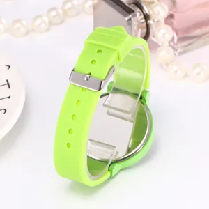 Detail view of neon green silicone watch strap with silver buckle and metallic back cover