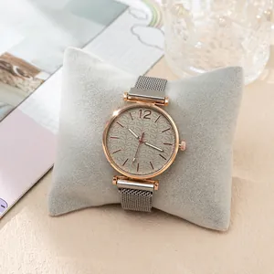 Detailed close-up of rose gold watch with grey leaf-patterned dial on display pillow