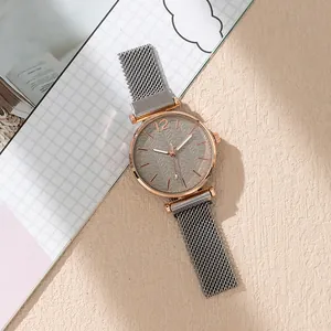 Rose gold watch with gray patterned dial and magnetic Milanese strap on beige texture