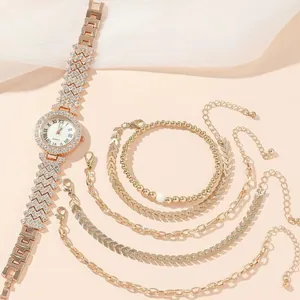Detailed set of rose gold quartz watch and crystal bracelets on soft silk fabric