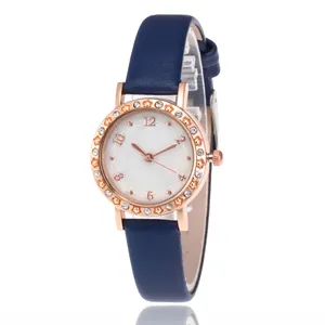 Women's blue leather strap watch with rose gold case and rhinestone bezel on white background
