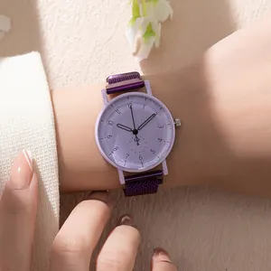 Close-up of purple quartz watch with faceted dial and magnetic mesh strap on wrist