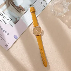 Detail of yellow leather strap quartz watch with rose gold case and feather texture dial