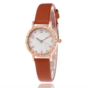 Elegant rose gold women's watch with brown leather strap and rhinestone star bezel