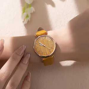 Close-up of yellow leather quartz watch with textured dial and rose gold metal case