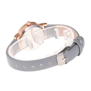 Rose gold watch with gray leather strap and shell dial shown from a side view