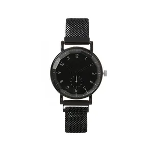 Detail of minimalist quartz watch featuring a black Milanese mesh band and faceted glass