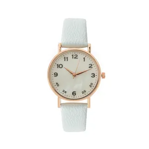Detail of mint green leather strap and rose gold quartz watch dial with Arabic numerals