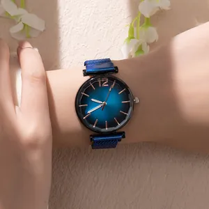 Close-up of women's watch with gradient blue dial and matching metal mesh strap