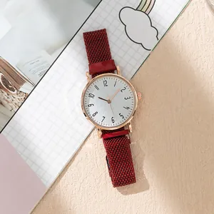 Close-up of women quartz watch with red mesh strap and rose gold round case on desk