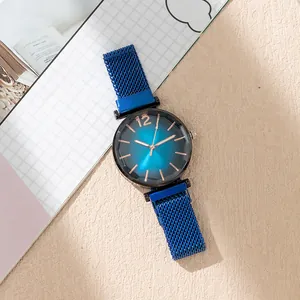 Detail of blue gradient watch dial with faceted glass and magnetic mesh band