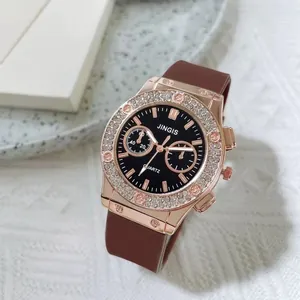 Detail of rose gold diamond-bezel quartz watch with black dial and brown silicone strap