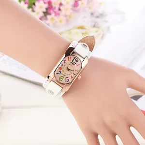 Detail of rose gold rectangular quartz watch with colorful numbers and white rivet leather strap