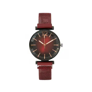 Detail of red gradient watch dial with faceted glass and magnetic mesh band strap
