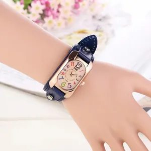 Vintage rose gold rectangle watch with dark blue leather cuff strap and colorful numerals