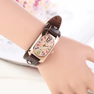 Retro quartz watch with colorful numerals and a wide brown leather cuff strap on wrist