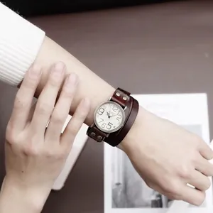 Gros plan d'une montre vintage en cuir multicouche avec rivets sur un poignet féminin