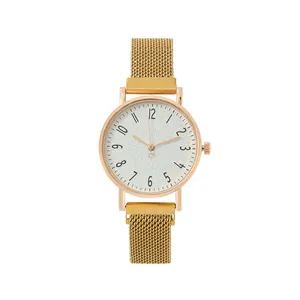 Macro detail of rose gold case with white ripple textured dial and mesh band