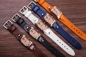 Detailed close-up of colorful dial quartz watches with leather straps on a wood background