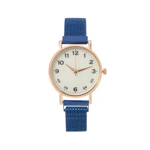 Macro detail of white dial quartz watch with rose gold case and blue mesh steel strap